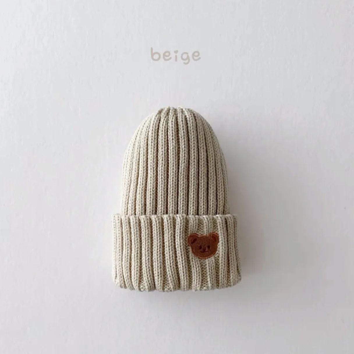 Little Tickle baby hat in beige color, featuring a cute embroidered bear face on the front.