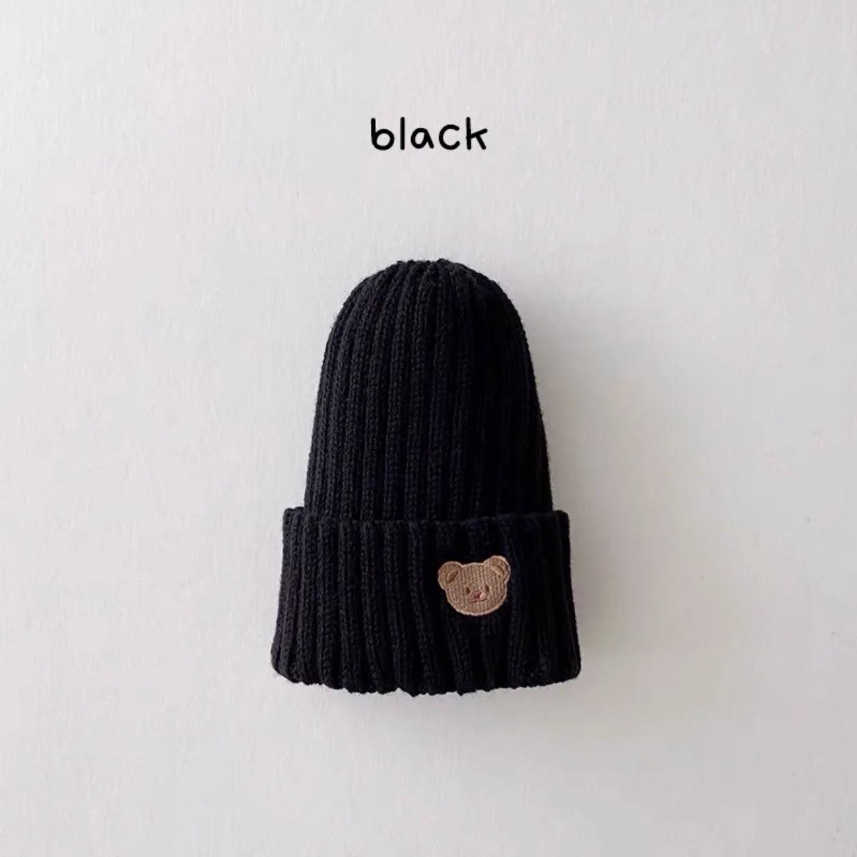 Little Tickle baby hat in black color, featuring a cute embroidered bear face on the front.