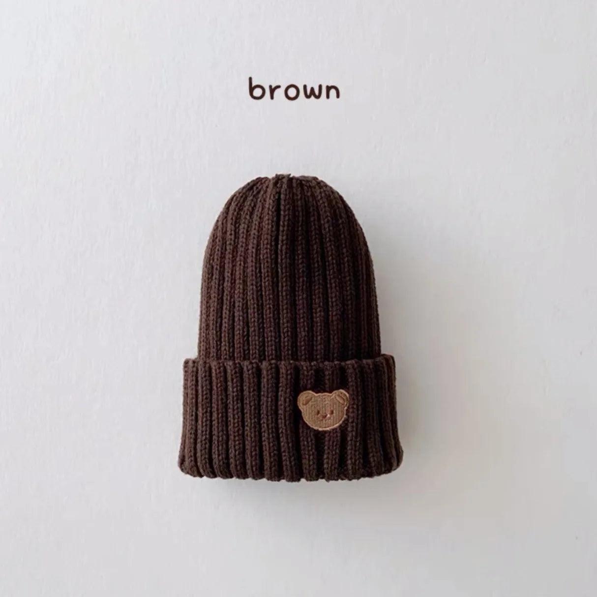 Little Tickle baby hat in brown color, featuring a cute embroidered bear face on the front.