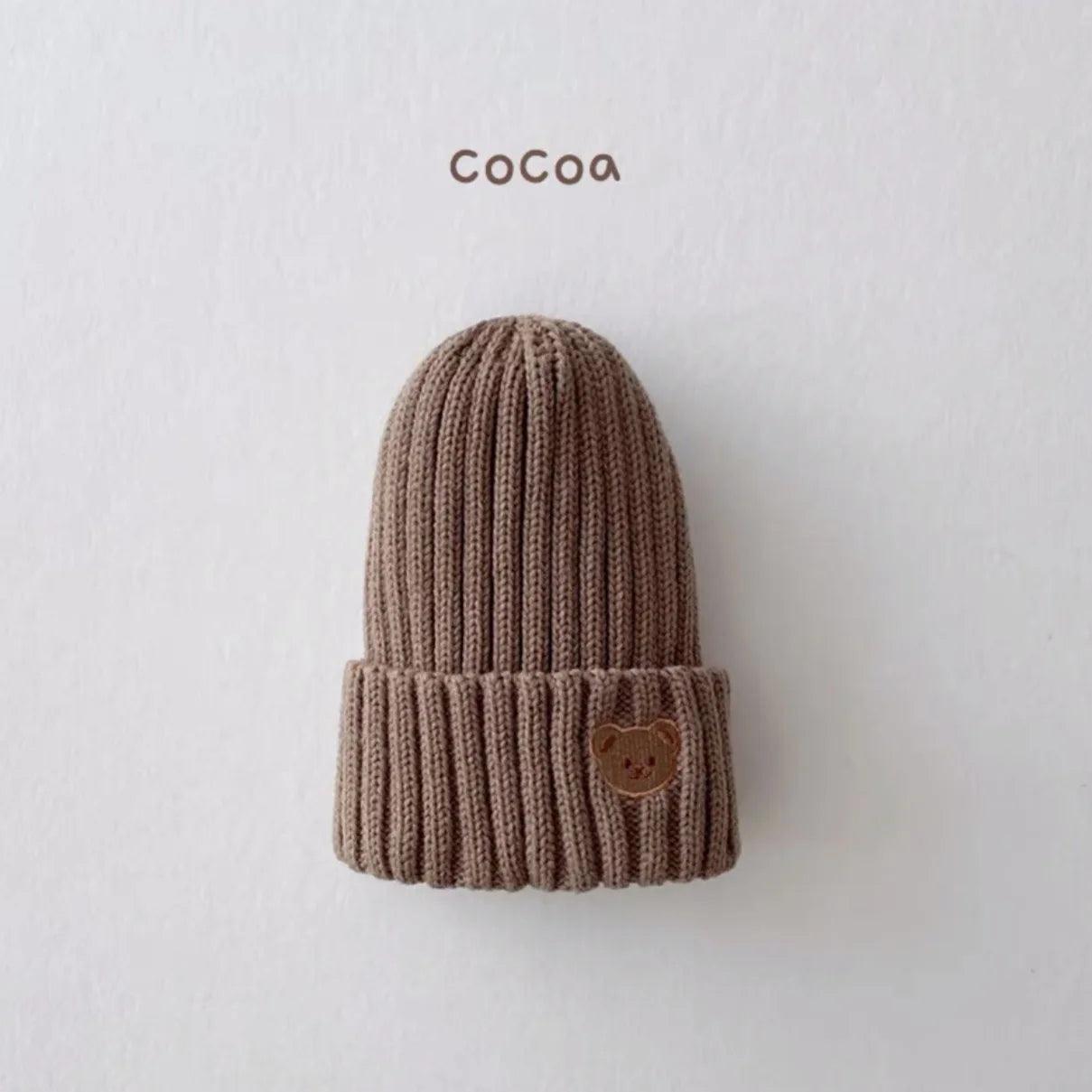 Little Tickle baby hat in cocoa color, featuring a cute embroidered bear face on the front.