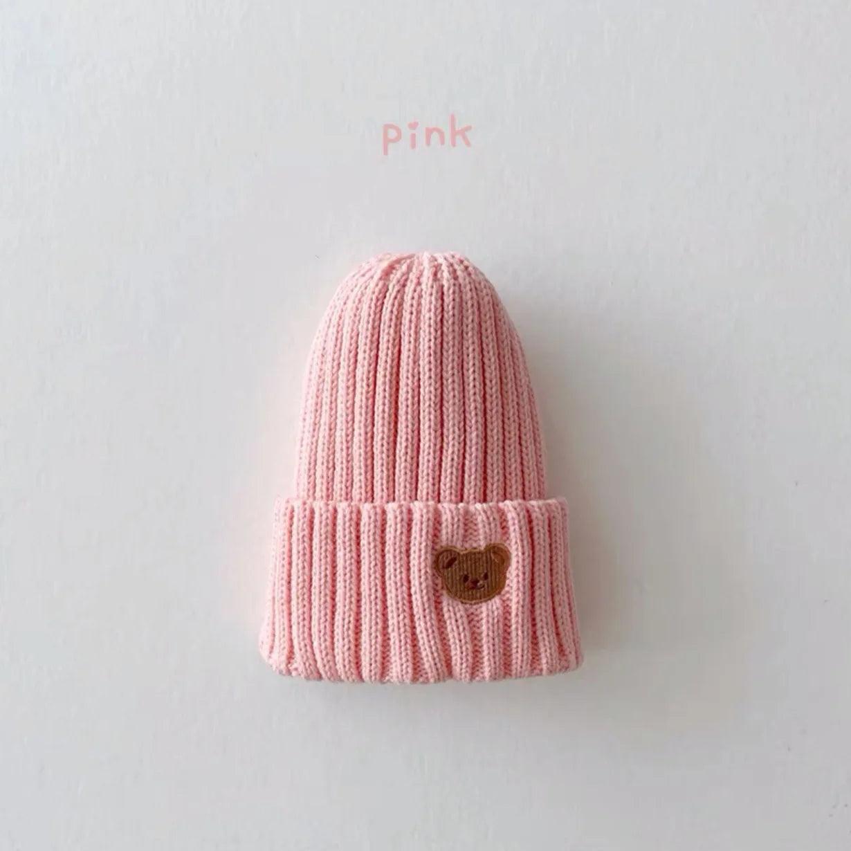 Little Tickle baby hat in pink color, featuring a cute embroidered bear face on the front.