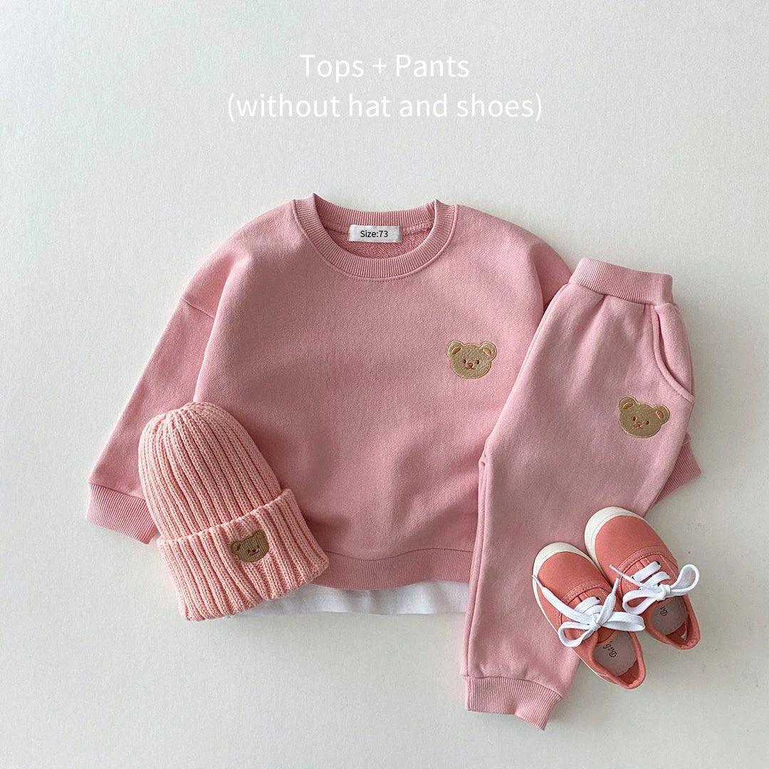 Soft and cozy pink baby outfit set featuring a sweatshirt and matching pants with adorable embroidered bear face details